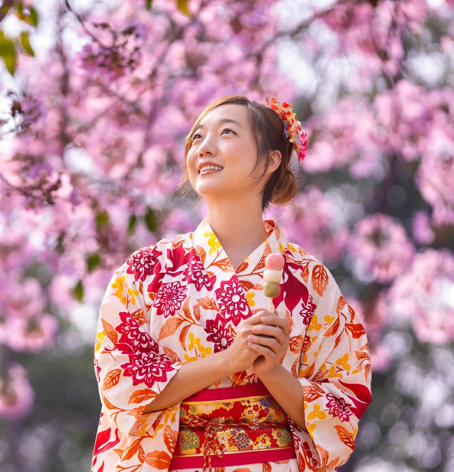 piękna Japonka w kimonie pod drzewem kwitnącej sakury